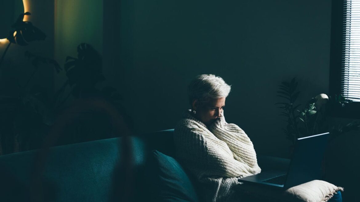 Sad woman using laptop at home