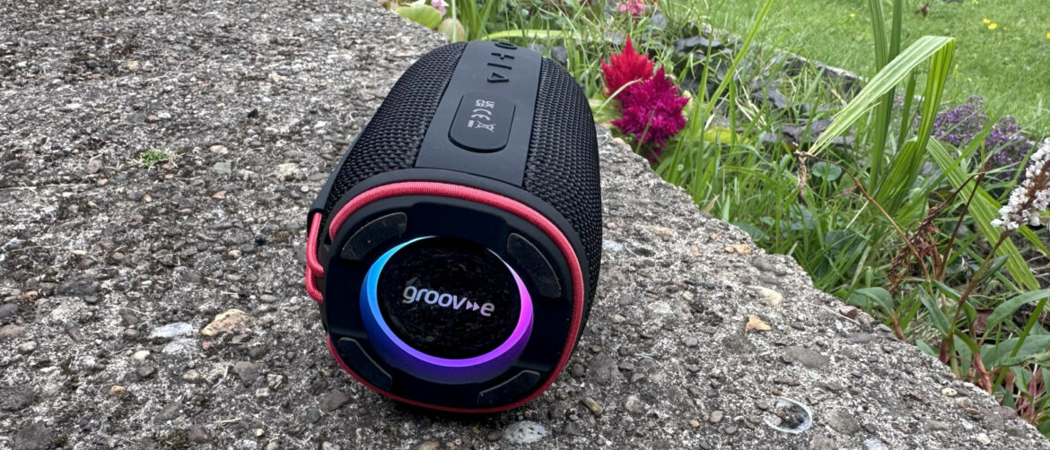 Groov-e's Wave Glow with illuminated ELD lights on it's end, lying on its side in a garden