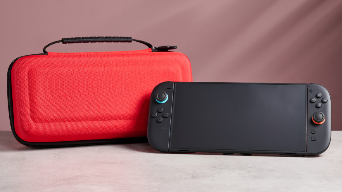 The Nintendo Switch 2 in front of the Nacon Hard Carrying Case for Nintendo Switch 2, with a pink background behind it.