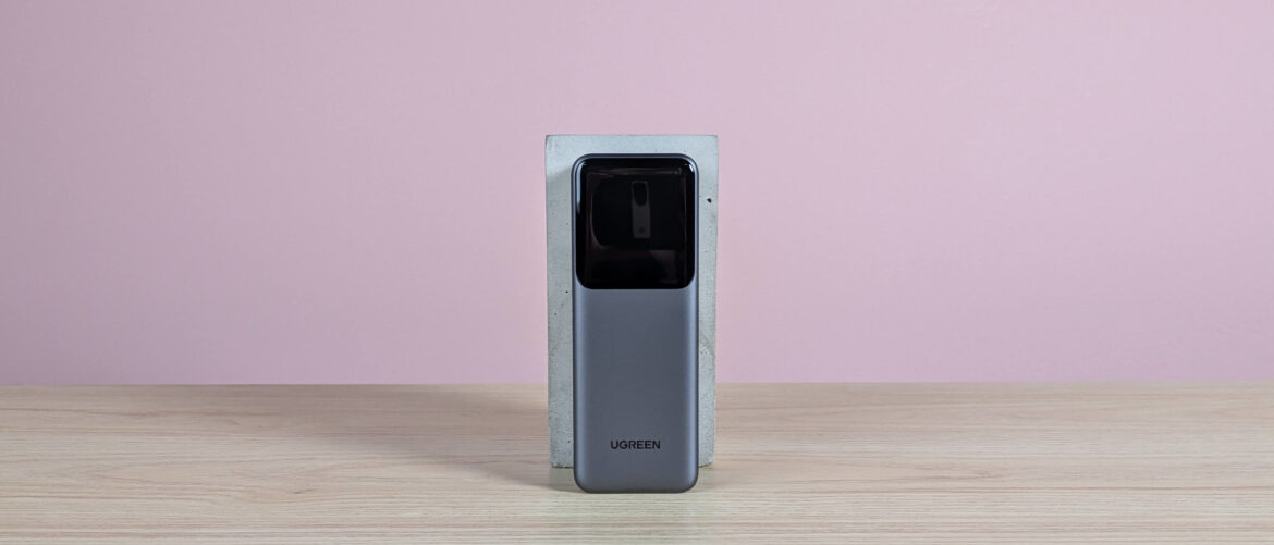 Ugreen Nexode Power Bank 20000mAh 165W leaning on plinth on desk with pink background