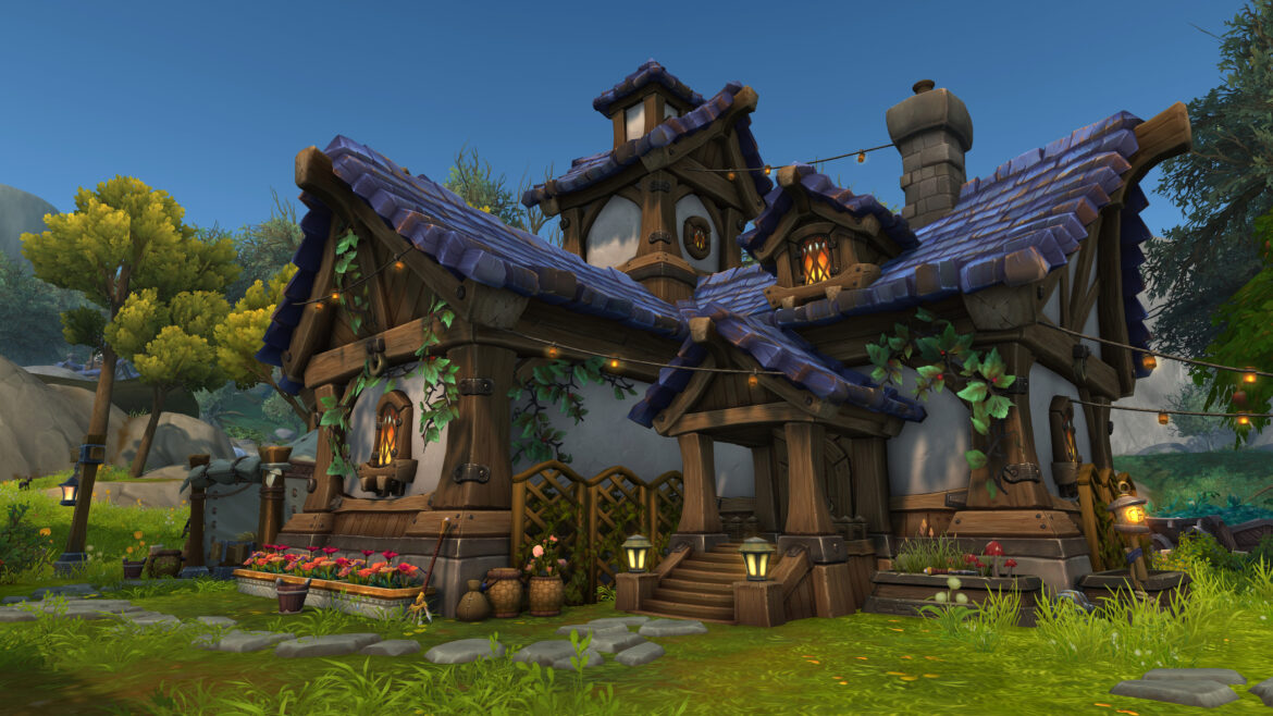 An in-development screenshot of World of Warcraft's player housing, which is coming in the Midnight expansion. A blue-roofed cottage covered in vines and lights sits in a valley.