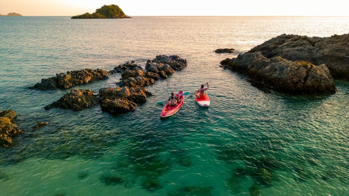 A photo of two women kayaking through the water in Thailand (gettyimages-1485301769)