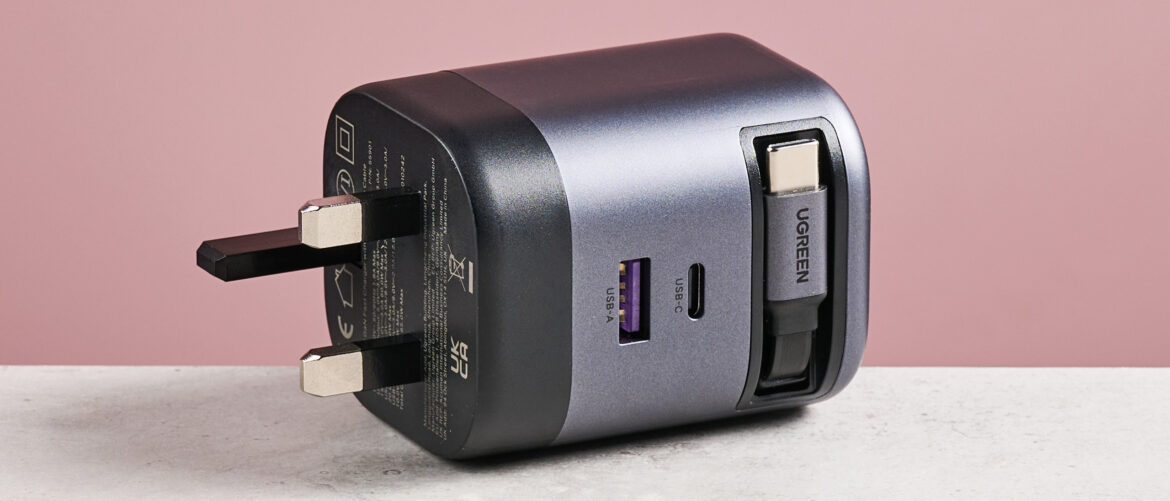 UGreen Nexode 65W Charger with Retractable USB-C Cable on its side against pink background